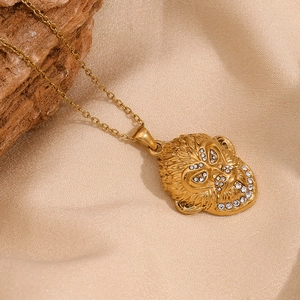 Détail d'un pendentif roi singe plaqué or 18K avec strass blancs sur une chaîne à maillons