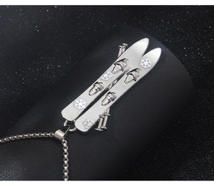 Macro shot of silver stainless steel snowboard pendant with snowflake engraving on a dark base