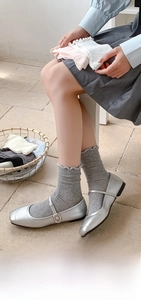 Detail of grey cotton crew socks featuring ruffled edges and soft knit texture