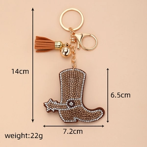 Detail view of crystal-studded brown cowboy boot keychain with tassel and dimensions