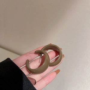 Close-up of elegant brown resin C-shaped hoop earrings with a smooth polished finish