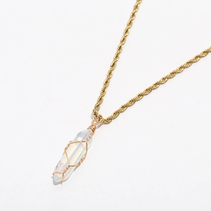 Macro view of handmade gold wire-wrapped white crystal pendant on twisted rope chain