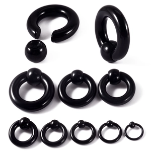 Detailed set of black acrylic captive bead rings and C-rings in various sizes on white