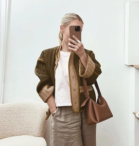 Close-up of olive green quilted jacket featuring khaki contrast trim and button closure