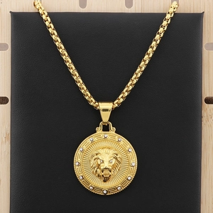 Detailed close-up of golden lion head pendant with rhinestone inlay and Greek key border