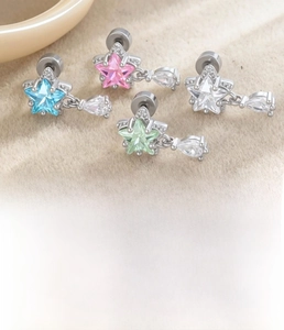 Detailed view of silver star earrings with colored zircon and teardrop pendants