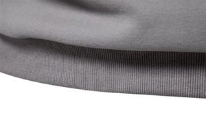 Close-up of the grey knit sweatshirt showing rib-knit hem details and fabric texture