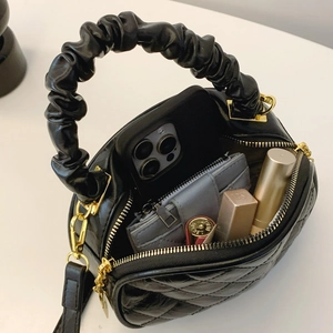 Interior view showing the large capacity of black quilted handbag with scrunchie handle