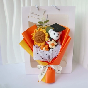 Detail of graduation bouquet with hand-knitted sunflower and bear in window gift bag