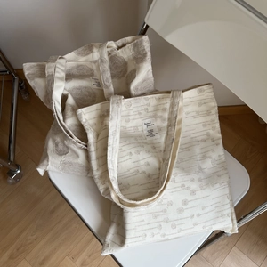 Detail view of cotton linen tote bags with jacquard textures on a white folding chair