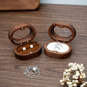 Detail of walnut wood oval jewelry box showing magnetic closure and flocking lining