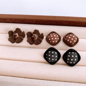 Macro shot of vintage fabric button stud earrings with polka dots and floral patterns