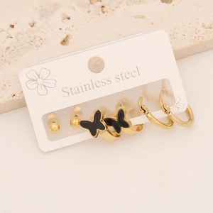 Detailed view of three pairs of gold stainless steel earrings on a white display card