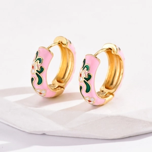 Macro detail of pink enamel flower hoop earrings with intricate floral patterns