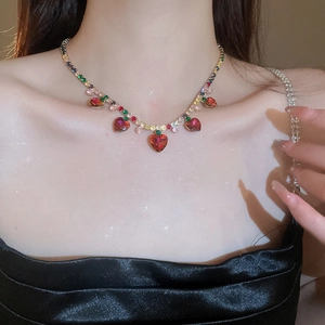Close-up of luxury gold heart necklace with colorful zircon gemstones on female model