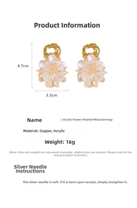 Détail des boucles d'oreilles fleur en acrylique crème avec anneaux dorés plissés et clous en argent