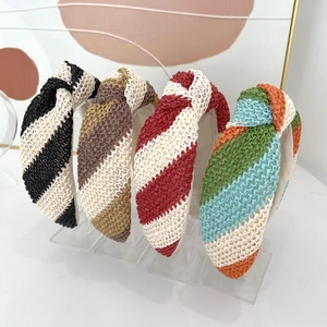 Détail de quatre serre-têtes noués avec texture tissée sur un présentoir transparent