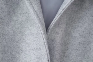 Détail du tissu en laine gris clair avec couture précise et doublure lisse