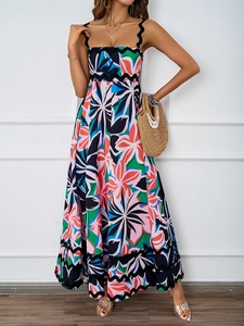Detailed view of spaghetti strap neckline and vibrant tropical floral print on maxi dress
