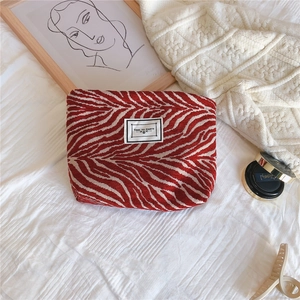 Detail of red and white zebra pattern canvas makeup bag with TIME TO PARTY slogan