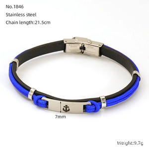 Close-up of anchor clasp detail on blue and black braided rope bracelet with steel accents