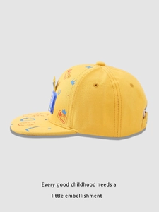 Detail view of yellow kids baseball cap with 3D blue monster and cartoon graffiti