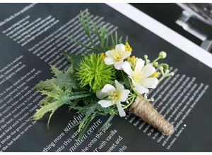Detailed close-up of forest style wedding boutonniere with white flowers and jute twine