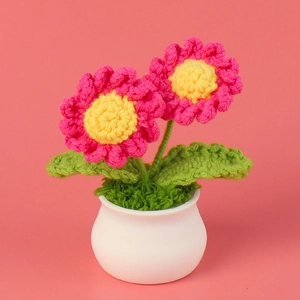 Detailed macro view of handmade pink crochet daisy flower in a small white pot
