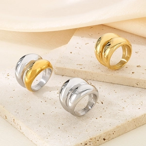 Polished wide arc rings in gold, silver, and two-tone stainless steel on stone