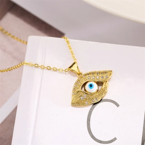 Close-up of golden evil eye pendant with sparkling crystals on a classic O-chain necklace