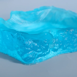 Macro shot of irregular blue translucent resin mold with ice-like texture details