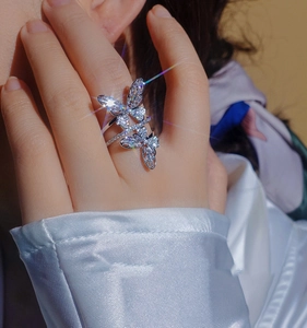 Close-up of elegant silver double butterfly ring with sparkling zircons on hand
