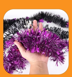Détail d'une guirlande d'Halloween violette avec fantômes argentés tenue à la main