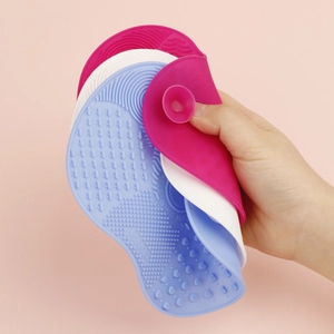 Close-up of flexible silicone brush cleaning mats in pink, white and blue colors