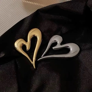Abstract hollow heart-shaped metal brooches in gold and silver on black silk