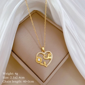 Detail of heart pendant necklace with sunflower and elephant design on silk background