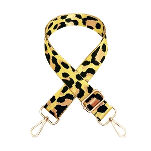Detail of adjustable leopard print nylon bag strap with gold metal buckles and swivel hooks