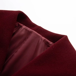 Close-up of wine red wool coat collar and shoulder showing premium stitching detail