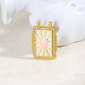 Macro view of gold rectangular enamel pendant with pink heart and zircon border