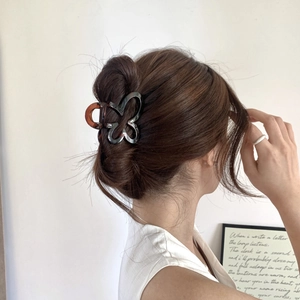 Close-up of a tortoiseshell butterfly hair claw clip worn on a woman's hair back
