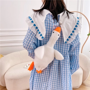 Cute white goose plush crossbody bag with adjustable strap worn by model in casual style