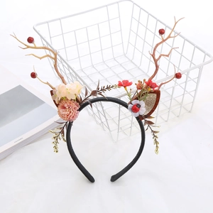 Detail of Christmas headband with reindeer antlers, red roses, berries and ladybug