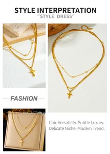 Detail of layered gold-plated stainless steel necklace with cross pendant and snake chain