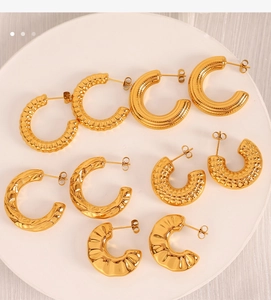 Collection of gold-toned chunky C-shaped hoop earrings with textured metal surfaces