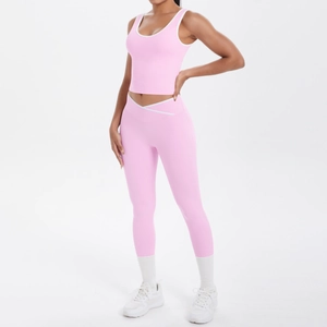 Pink two-piece yoga set with white piping and high-waist crossover leggings