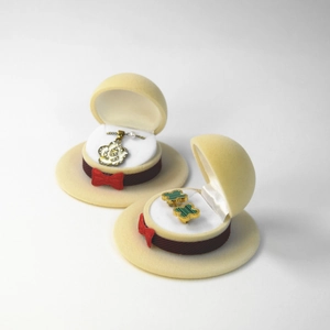 Detail view of cream cowboy hat jewelry box with red bow and stripe ribbon detail