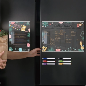 Detail of magnetic acrylic weekly planner on black fridge with colorful markers