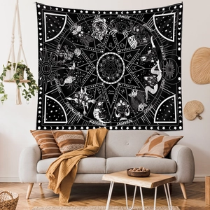 Detail of black and white zodiac tapestry featuring celestial sun, moon, and skull patterns