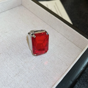 Detailed macro view of an oversized rectangular red gemstone ring with silver-tone claw setting