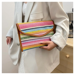 Detailed close-up of rainbow striped straw envelope clutch with brown PU trim